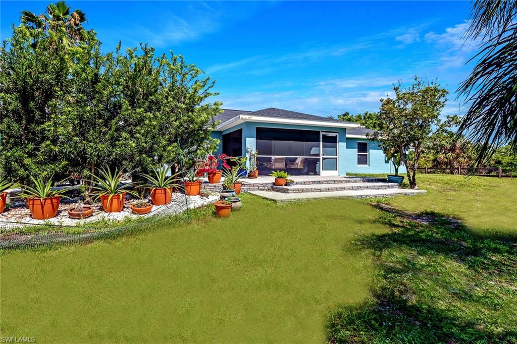 Rear view of house with a sunroom and a yard