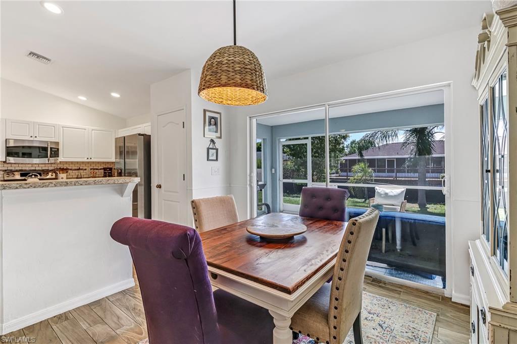 Dining room with recessed lighting, lofted ceiling, and light wood-type flooring