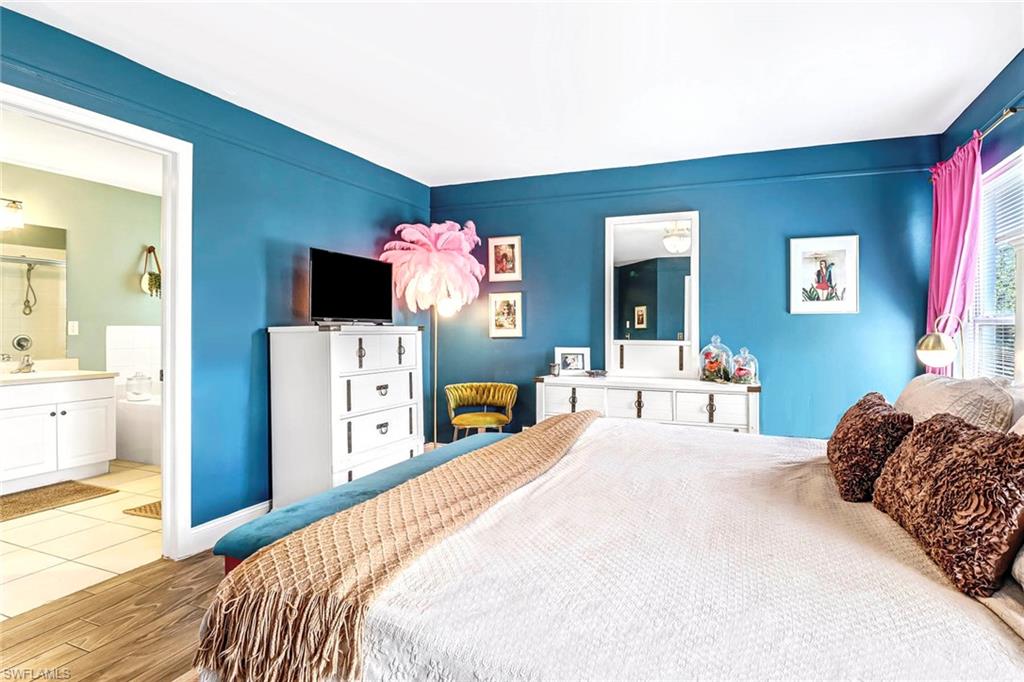 Bedroom featuring wood finished floors and ensuite bath