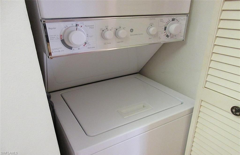 Washroom featuring stacked washer and clothes dryer