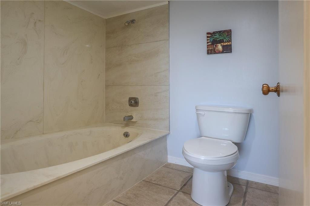 Full bathroom with a combined bath / shower with marble appearance and tile patterned floors