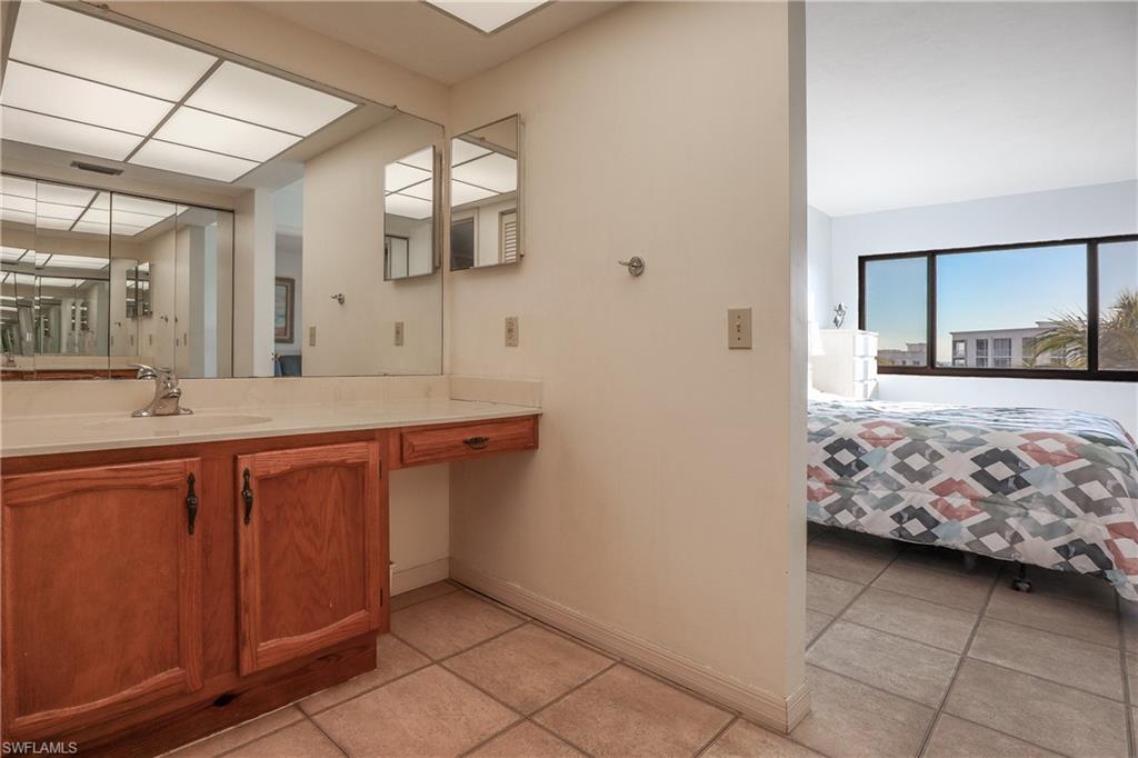 Ensuite bathroom featuring vanity and light tile patterned flooring