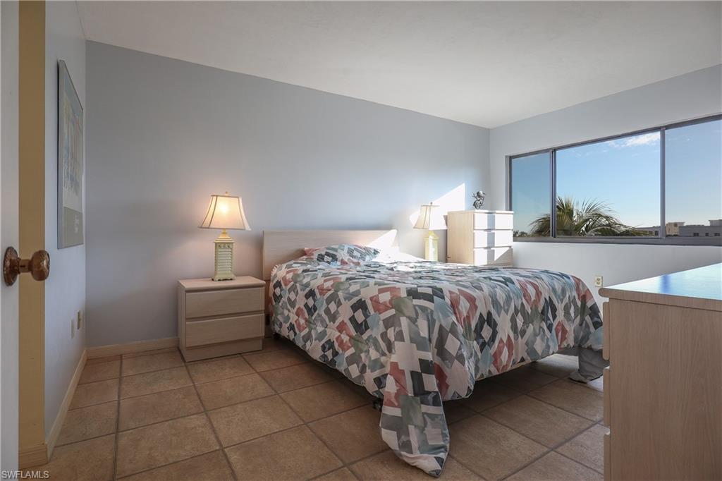 Bedroom with baseboards and light tile patterned floors