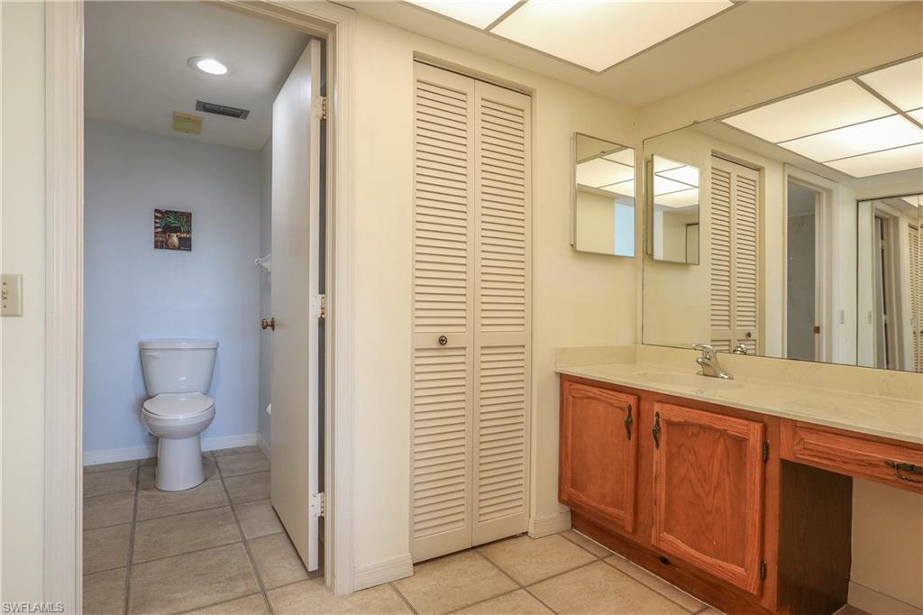 Bathroom featuring a closet, vanity, and light tile patterned floors