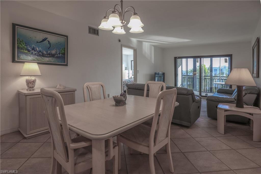 Dining area with light tile patterned floors and a chandelier