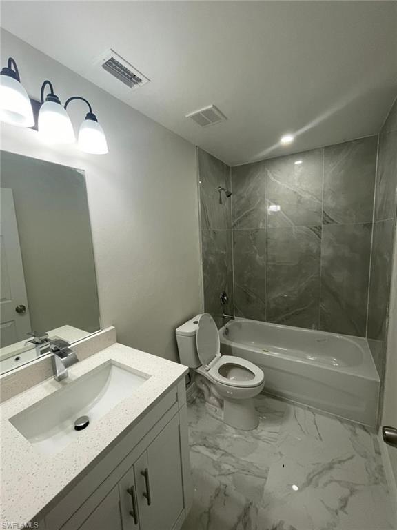 Bathroom featuring vanity,  shower combination, and marble finish flooring