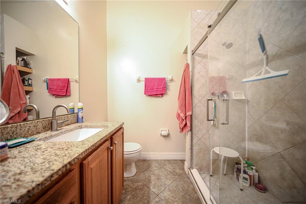 Full bathroom featuring vanity, a shower stall, and tile patterned floors