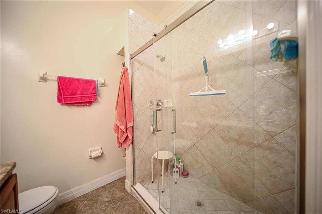 Bathroom with a shower stall, vanity, and tile patterned floors