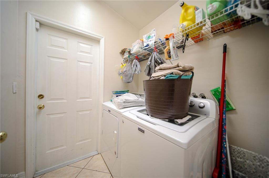 Laundry room featuring washing machine and dryer and light tile patterned floors