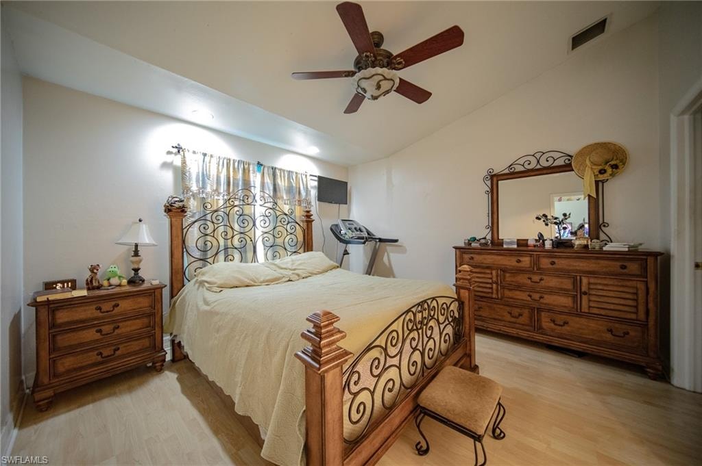 Bedroom with light wood-style flooring, vaulted ceiling, and ceiling fan