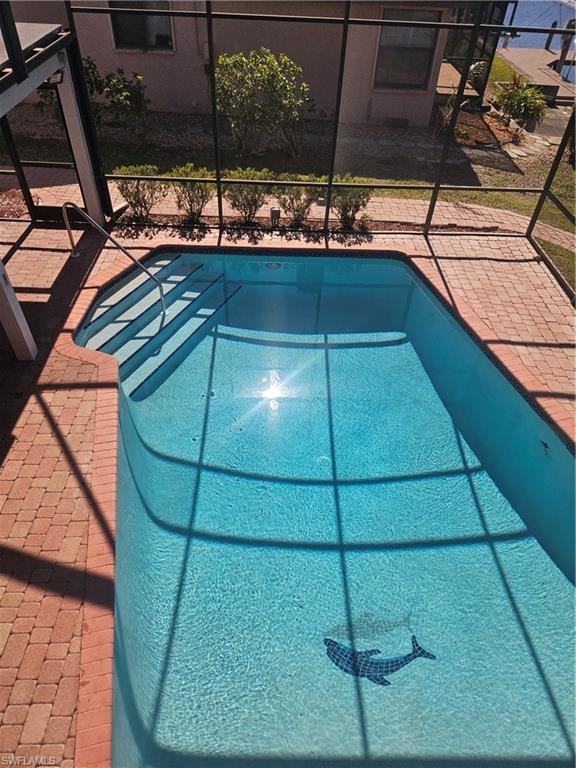 Swimming pool featuring a lanai and a patio