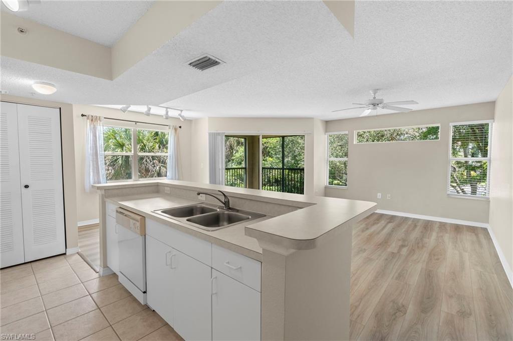 Kitchen featuring white dishwasher, plenty of natural light, light countertops, ceiling fan, and a textured ceiling