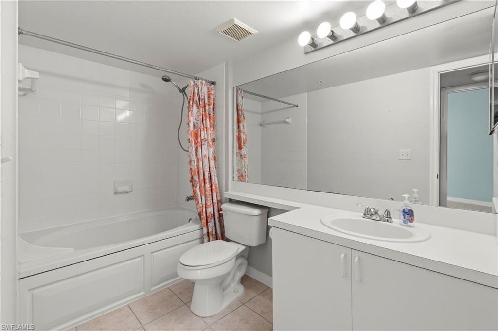 Bathroom featuring shower / tub combo, tile patterned flooring, and vanity