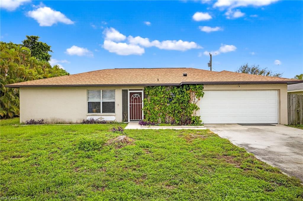 Single story home with concrete driveway, a garage, stucco siding, and a front lawn