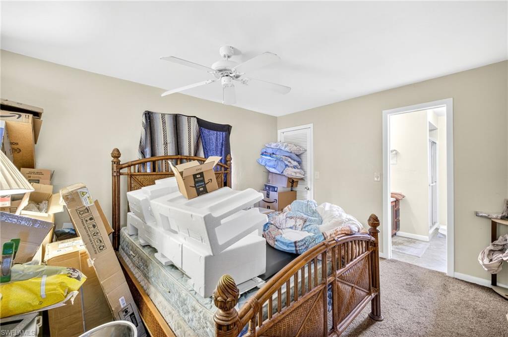 Carpeted bedroom with a ceiling fan and baseboards