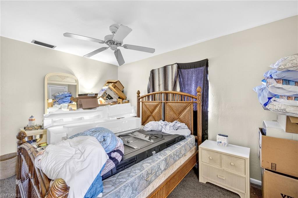 Bedroom with dark colored carpet and a ceiling fan