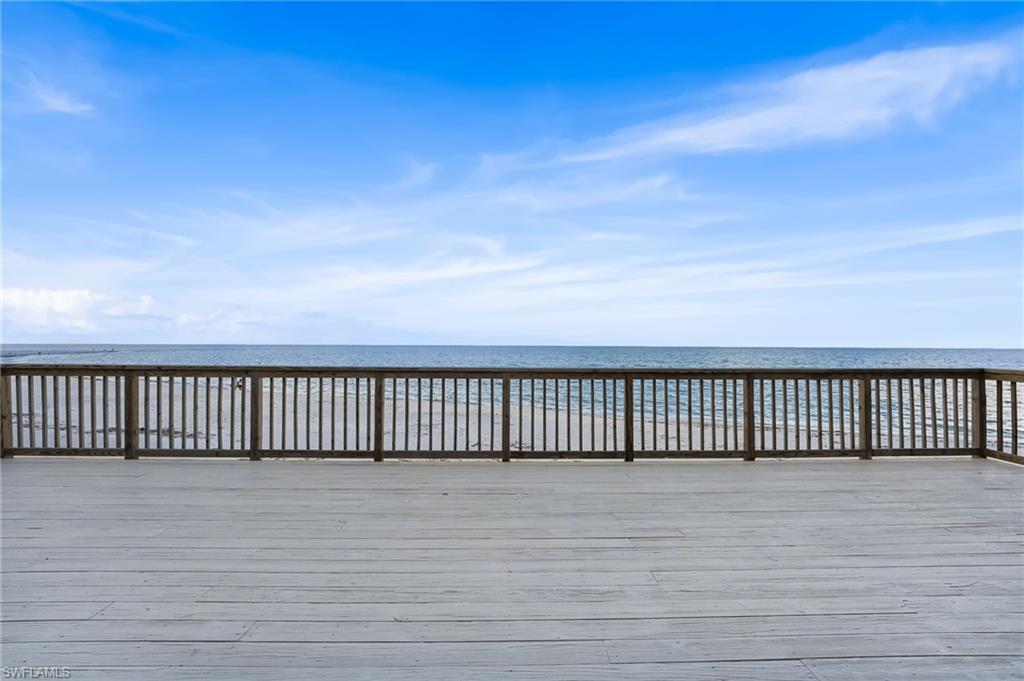 Empty room featuring light tile patterned flooring, a water view, and ceiling fan