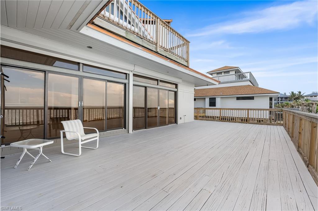 Unfurnished living room featuring a water view, wood finished floors, ceiling fan, a fireplace, and stairs