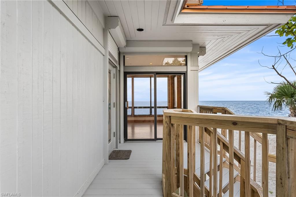 Unfurnished living room with ceiling fan, a water view, wood finished floors, a high end fireplace, and recessed lighting