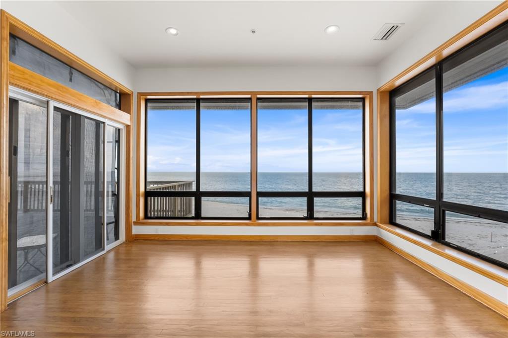 Back of property featuring a balcony, a sunroom, a metal roof, and stairway