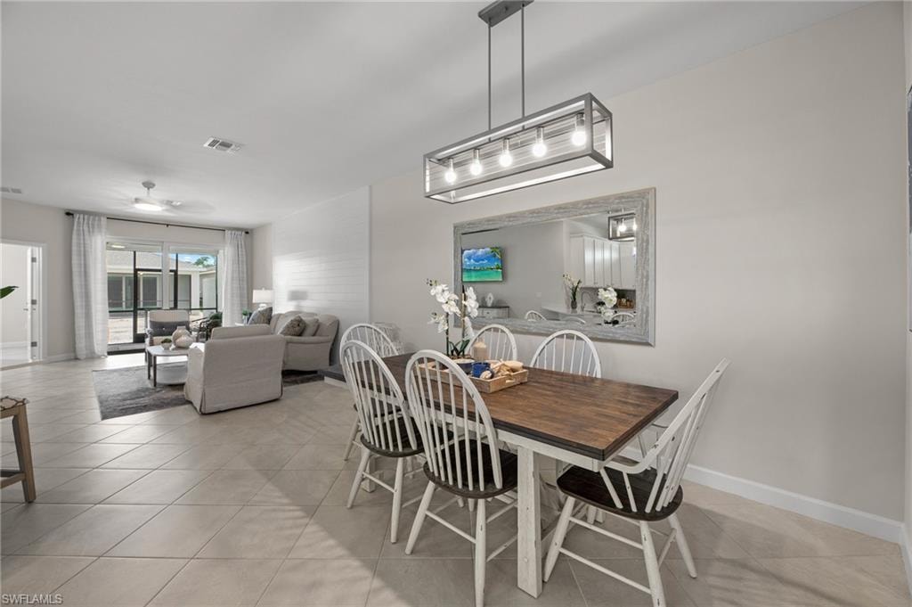 Dining room with light tile patterned floors and ceiling fan