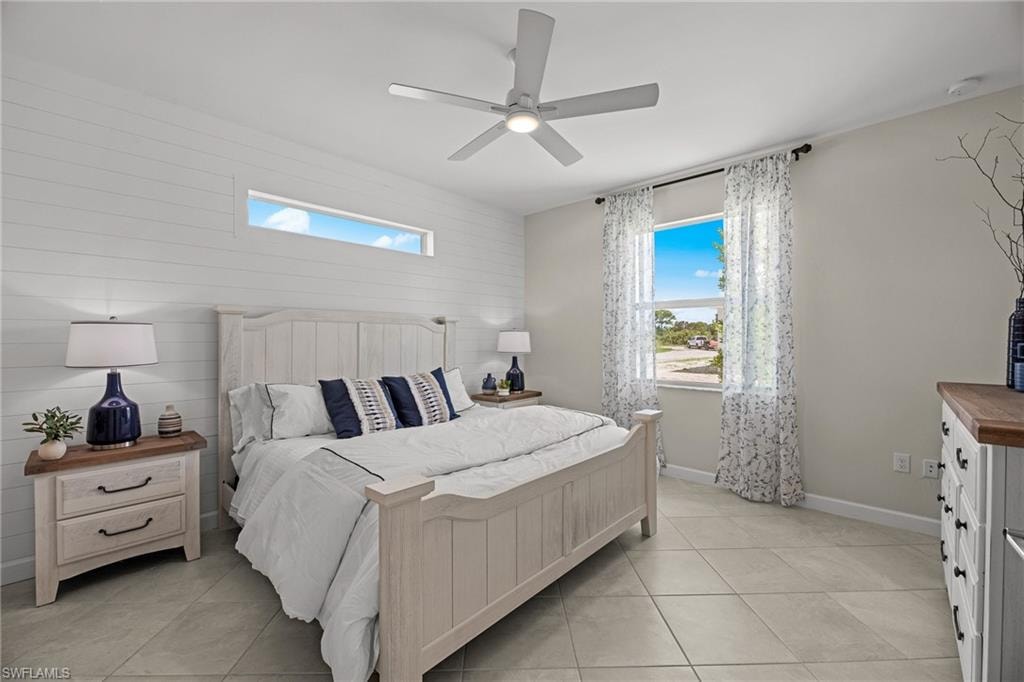 Bedroom with a skylight, light tile patterned floors, and ceiling fan