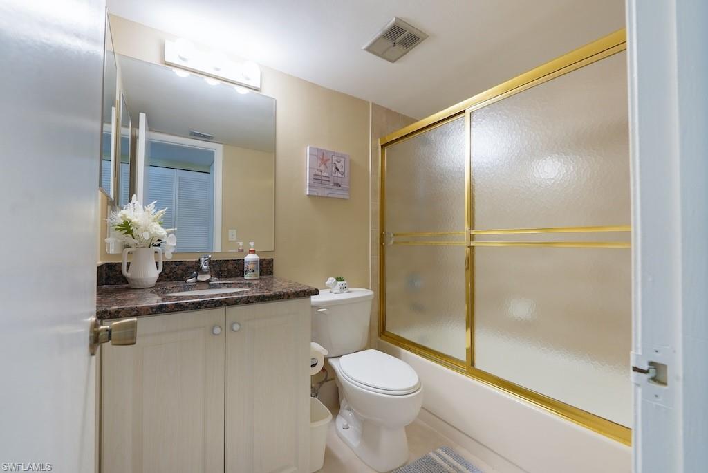 Full bath with vanity and combined bath / shower with glass door