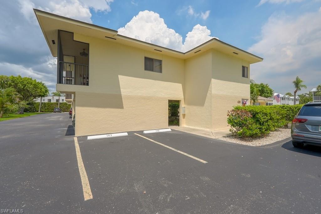 View of building exterior featuring uncovered parking