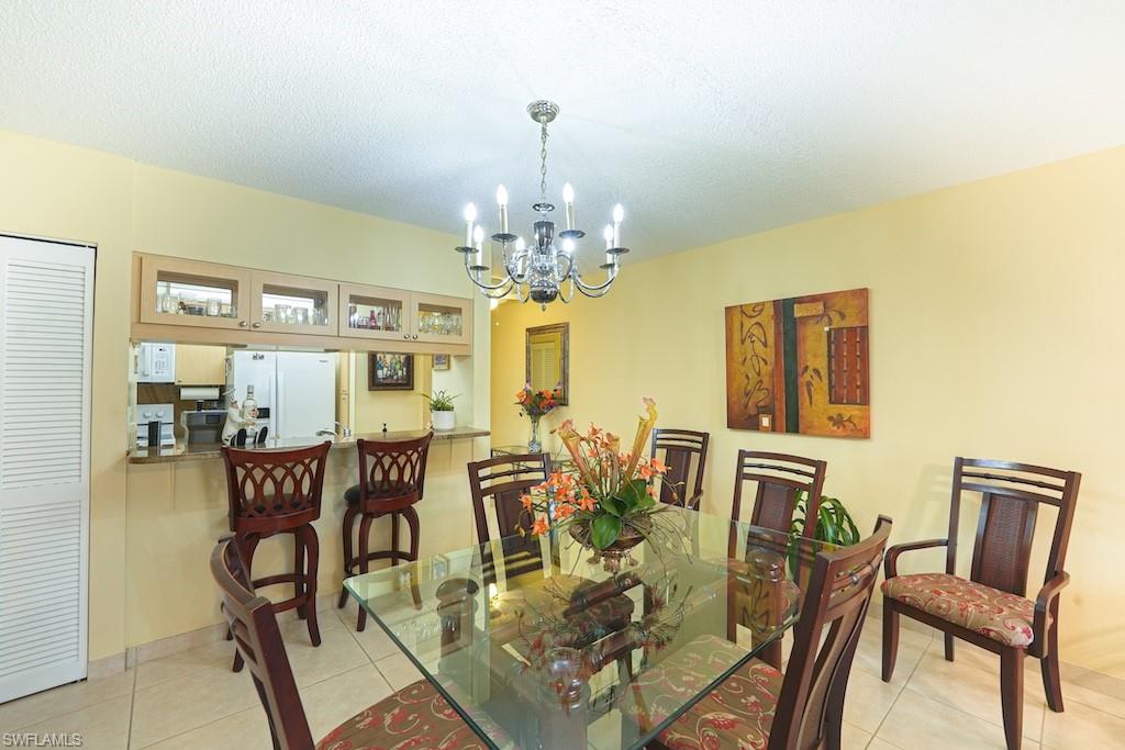 Dining room featuring a chandelier, light tile patterned floors, and a textured ceiling