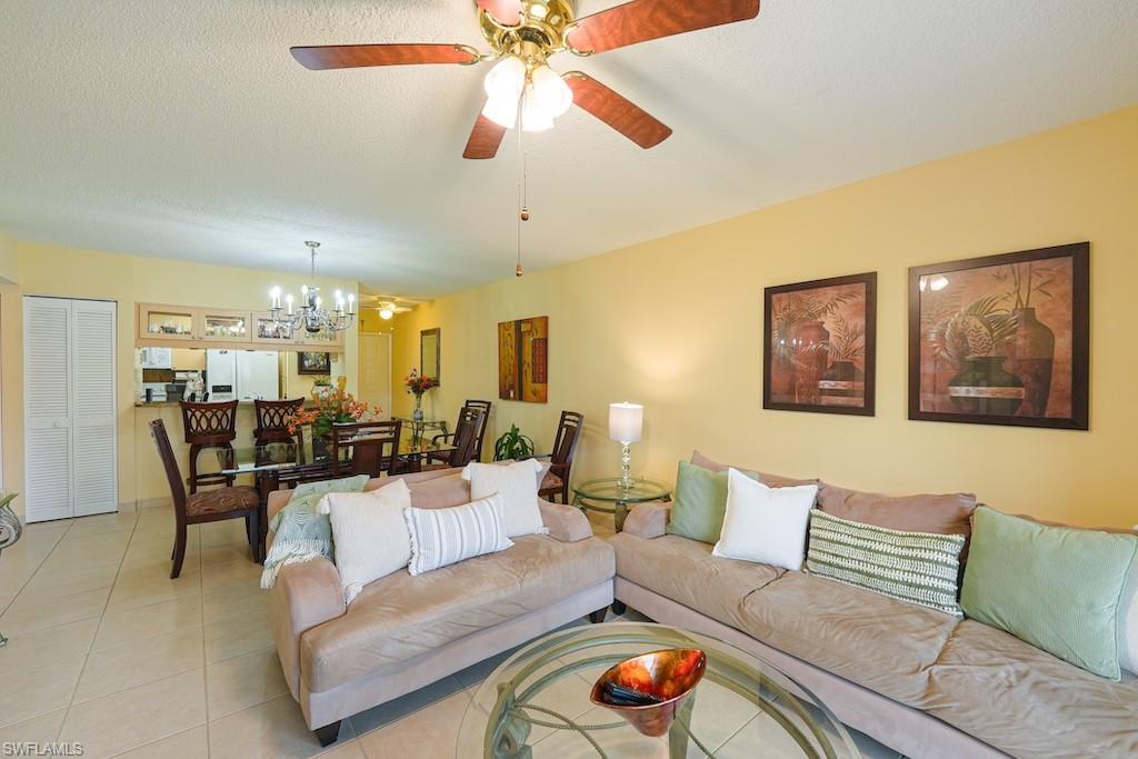 Living area featuring a chandelier, light tile patterned floors, and a ceiling fan