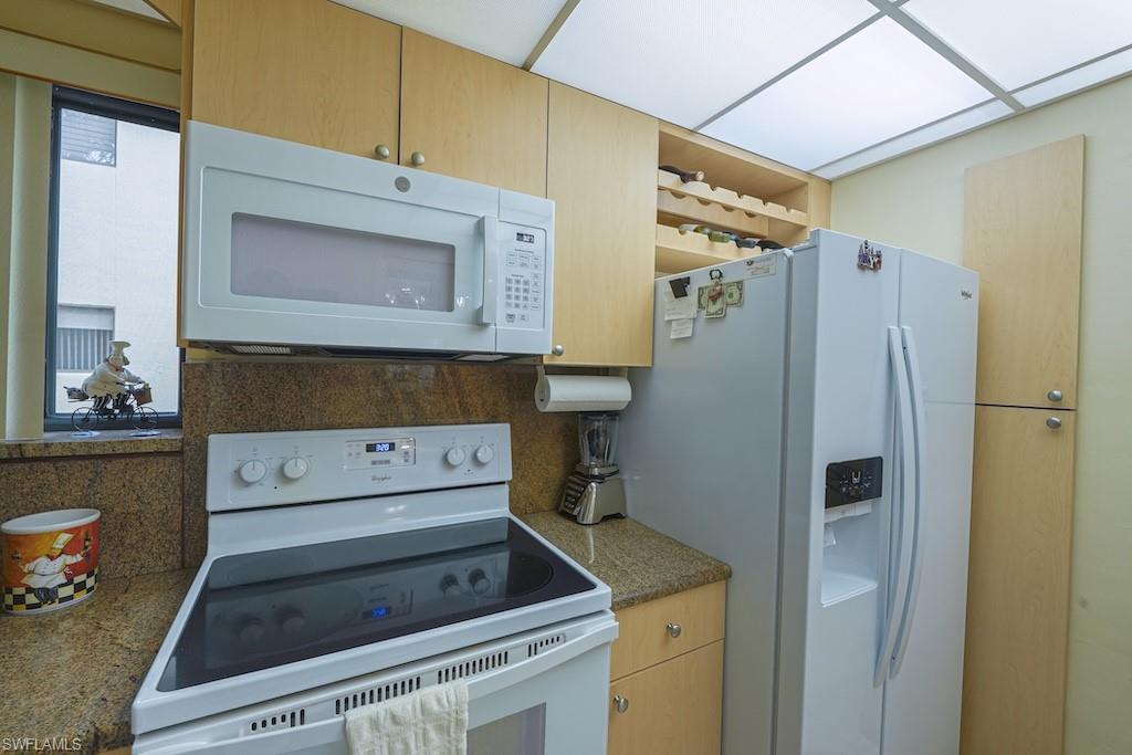 Kitchen featuring white appliances and tasteful backsplash