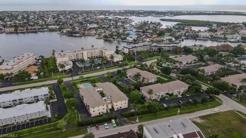 Aerial view of property's location featuring a nearby body of water and nearby suburban area