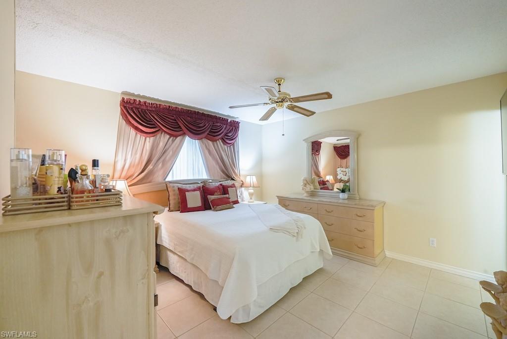 Bedroom with light tile patterned floors and ceiling fan