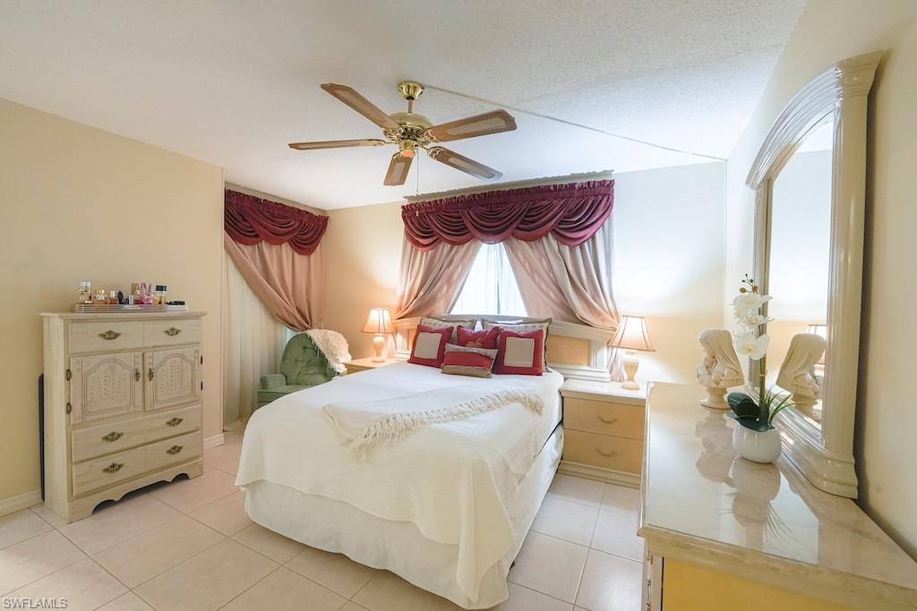 Bedroom with light tile patterned floors and a ceiling fan