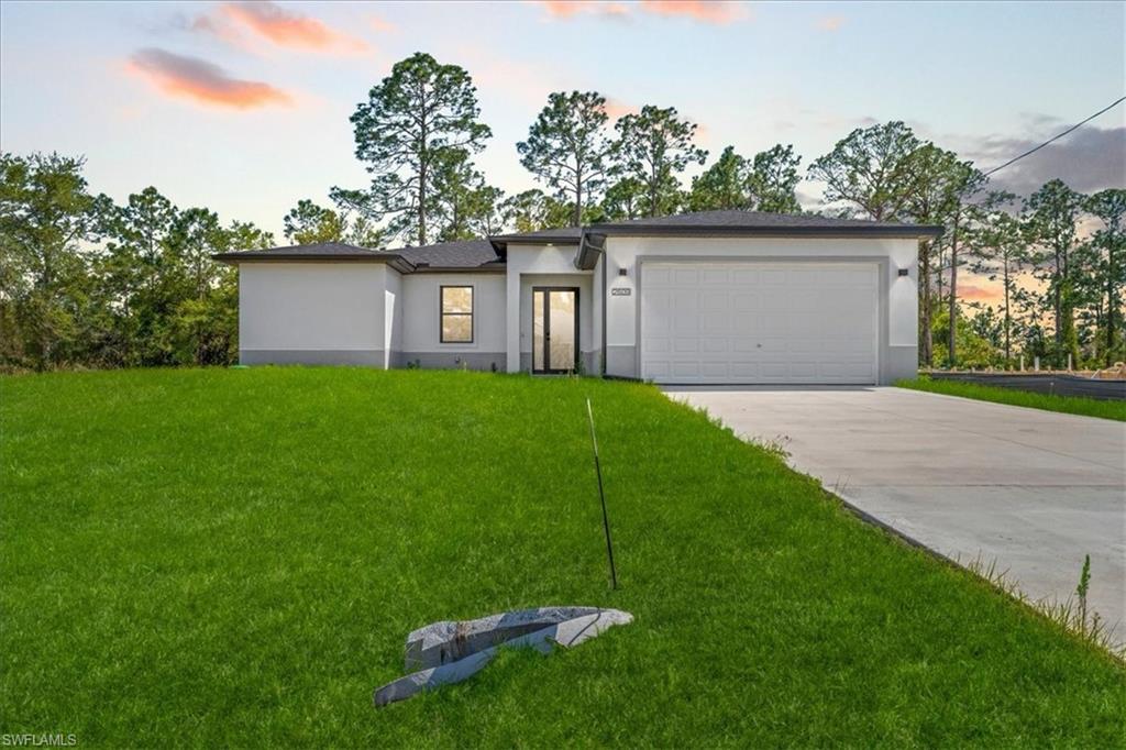 Contemporary facade with a single-car garage, concrete driveway, and ample front lawn