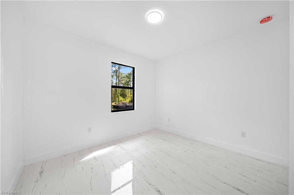 White walls with a single window, recessed lighting, and white tile flooring