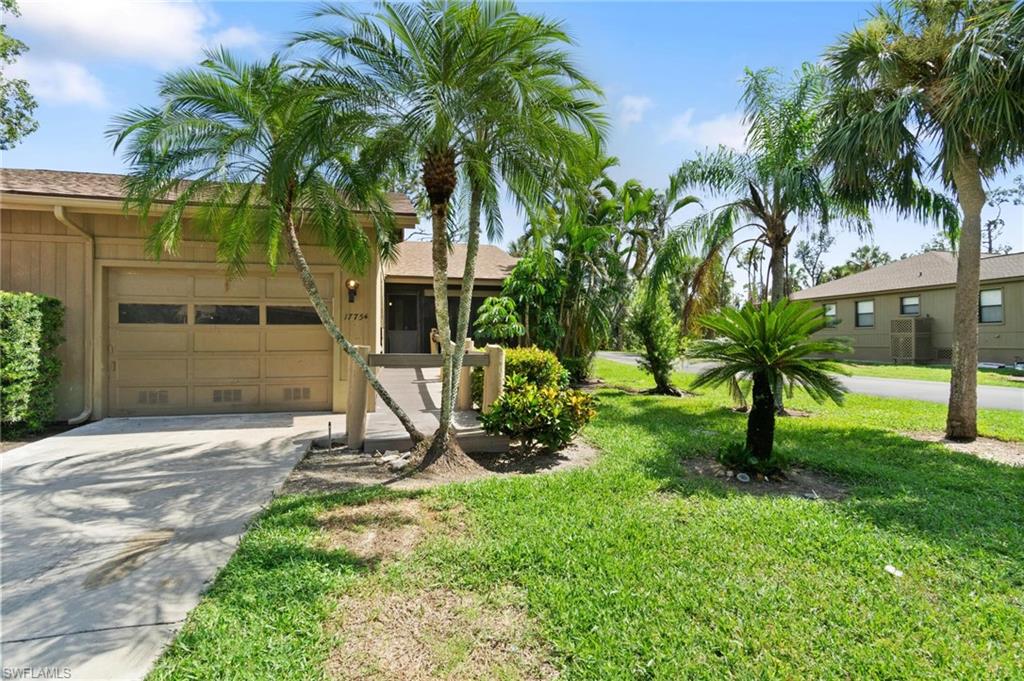 Ranch-style home with an attached garage, driveway, a front lawn, and stucco siding