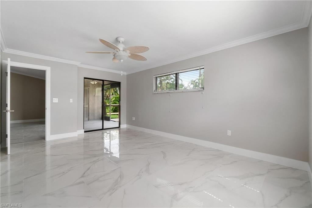 Empty room featuring ceiling fan, light marble finish flooring, and ornamental molding