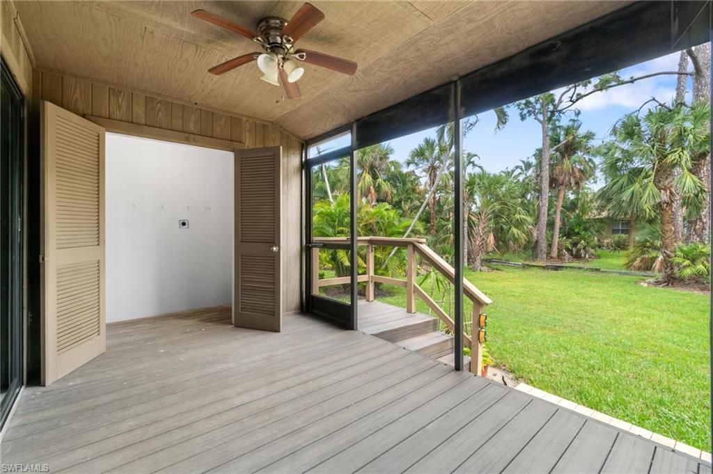 Wooden deck featuring a ceiling fan and a lawn