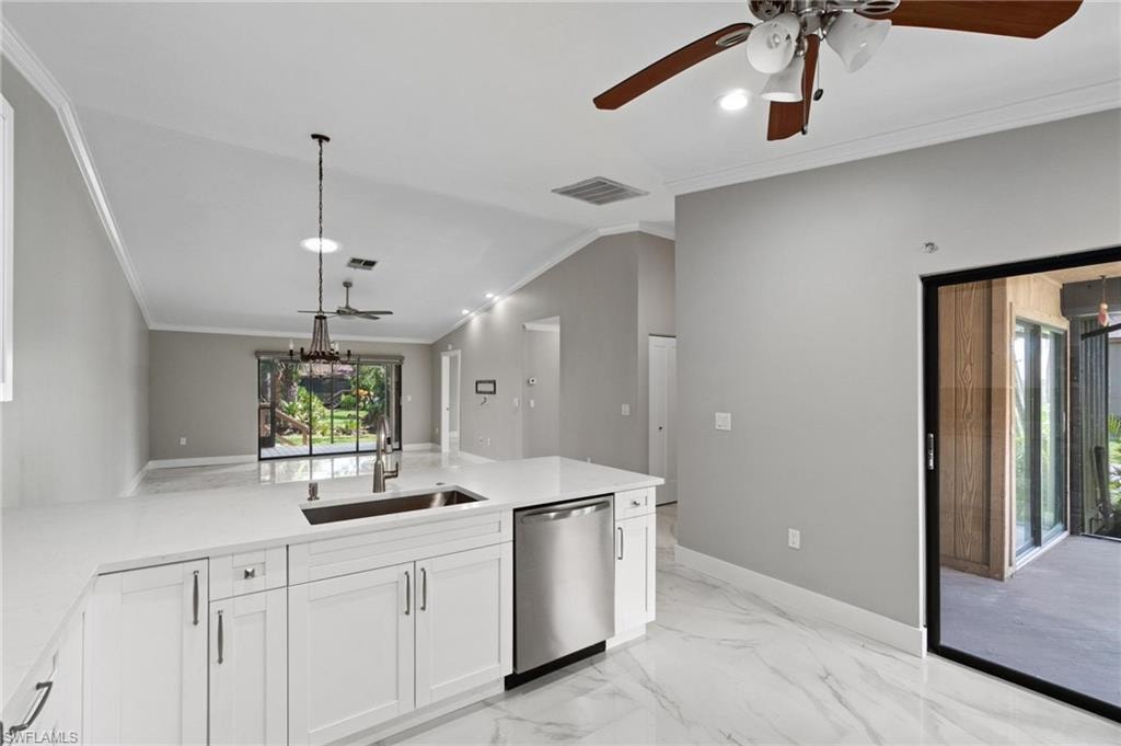 Kitchen featuring dishwasher, ornamental molding, a ceiling fan, a peninsula, and plenty of natural light