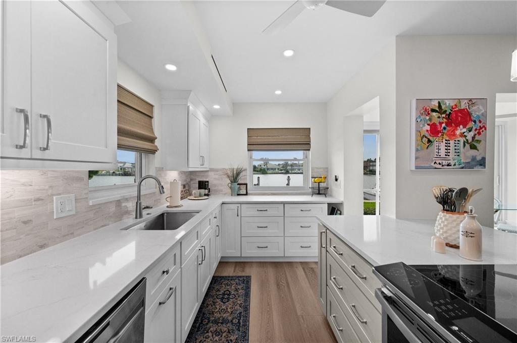Kitchen: Quartz countertops, generous island with seating, top-tiered stainless steel appliances, custom cabinetry