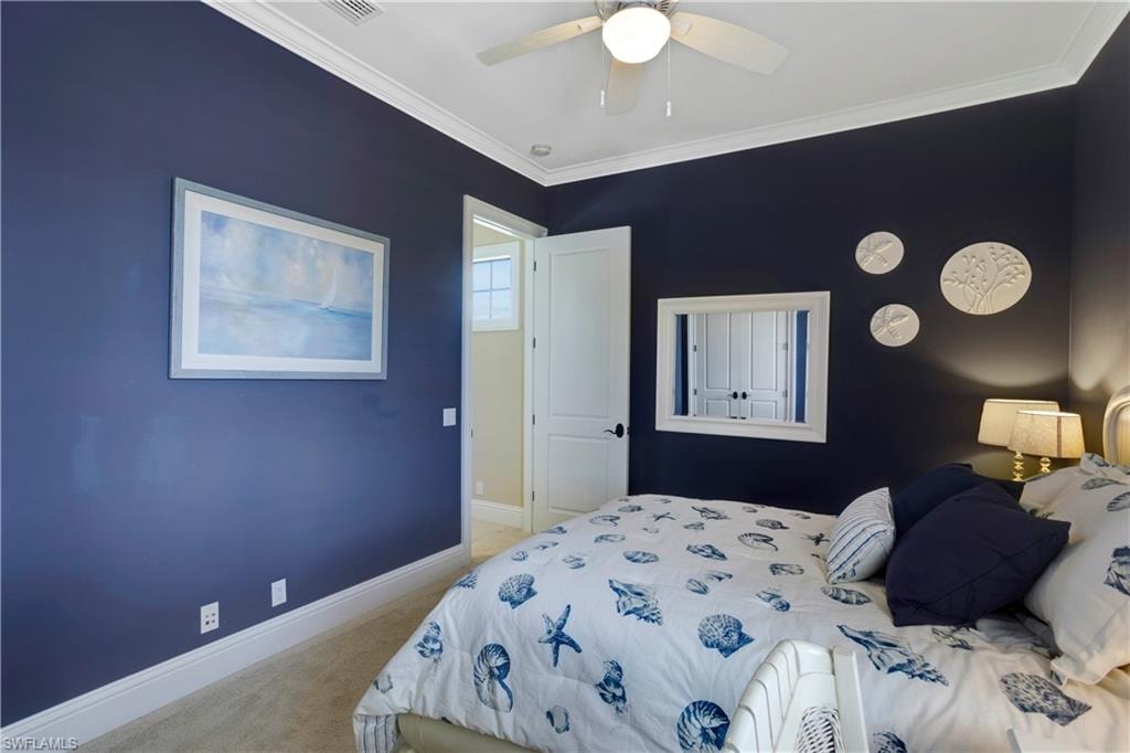 Bedroom featuring carpet floors, ornamental molding, and ceiling fan