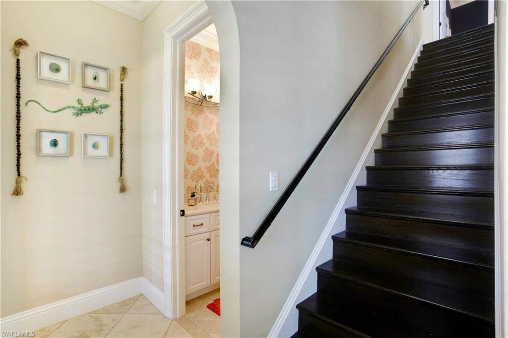 Wood Staircase to 2nd level showing full bath to left