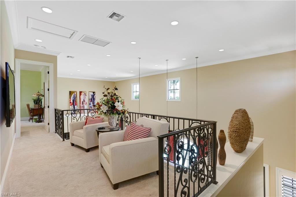 Hall featuring ornamental molding, light carpet, recessed lighting, and an upstairs landing