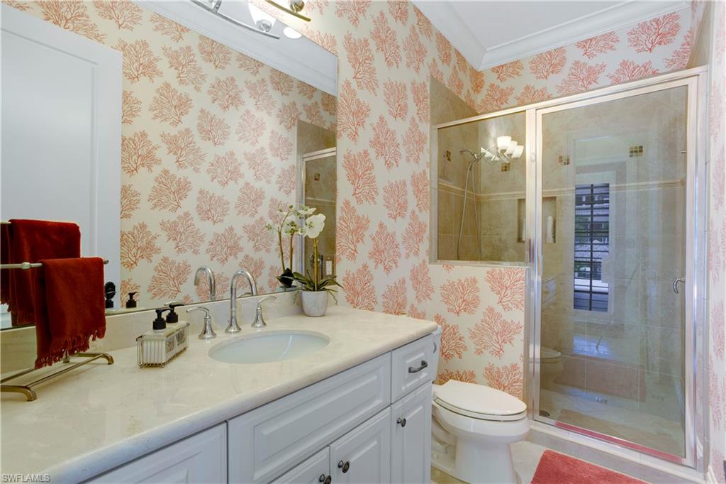 Full pool bath with vanity, crown molding, a stall shower, and wallpapered walls
