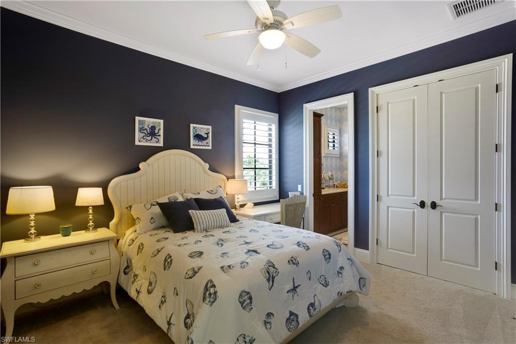 Carpeted bedroom featuring a closet, a ceiling fan, and crown molding