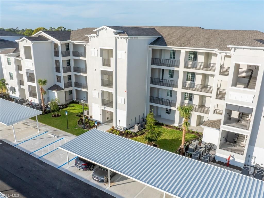 View of apartment building / complex with uncovered parking