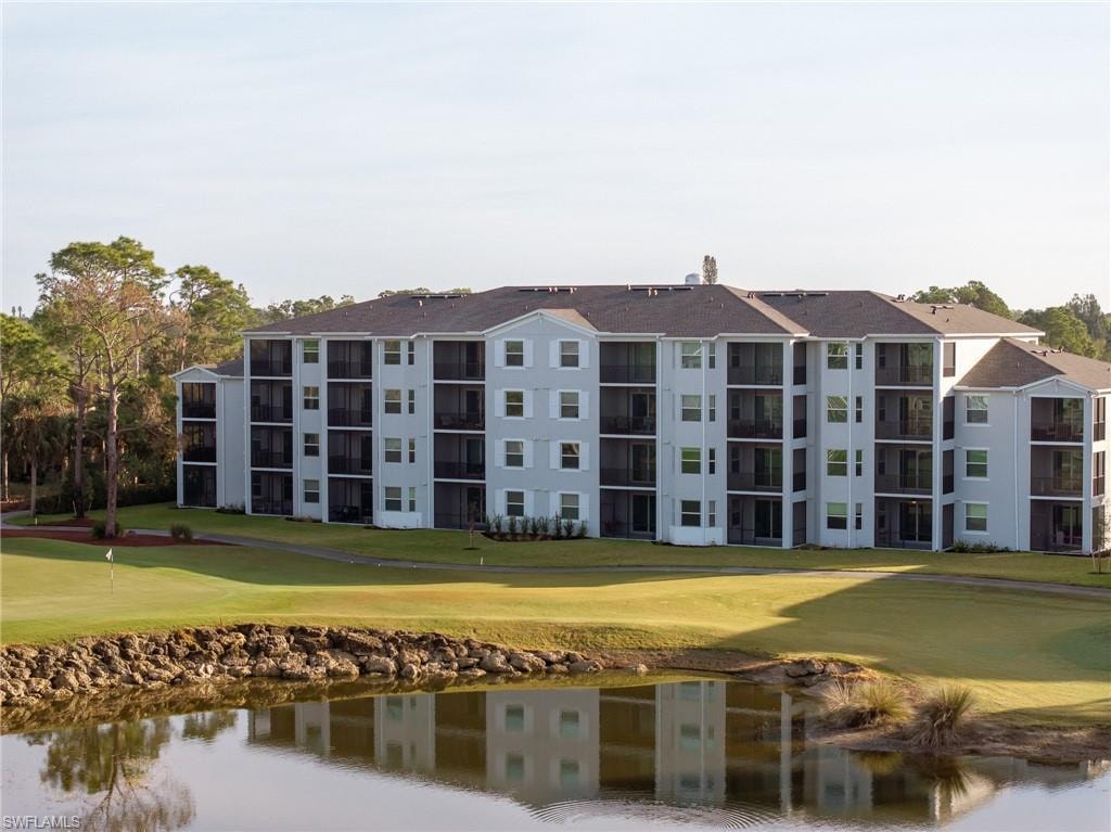 View of apartment building / complex with a water view and view of golf course