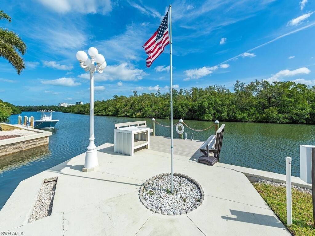 Dock featuring a water view and view of scattered trees