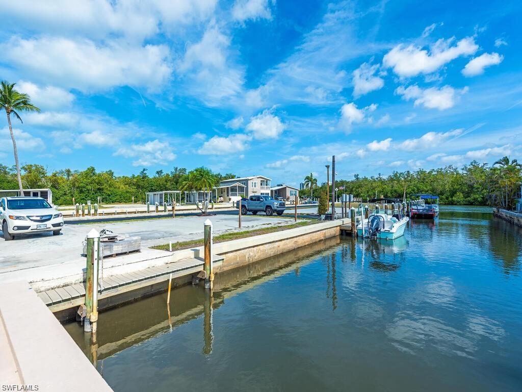 Dock with a water view, a boat ramp, and view of wooded area
